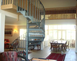 The dining area leads onto an outside rear terrace and gardens with patio furniture.